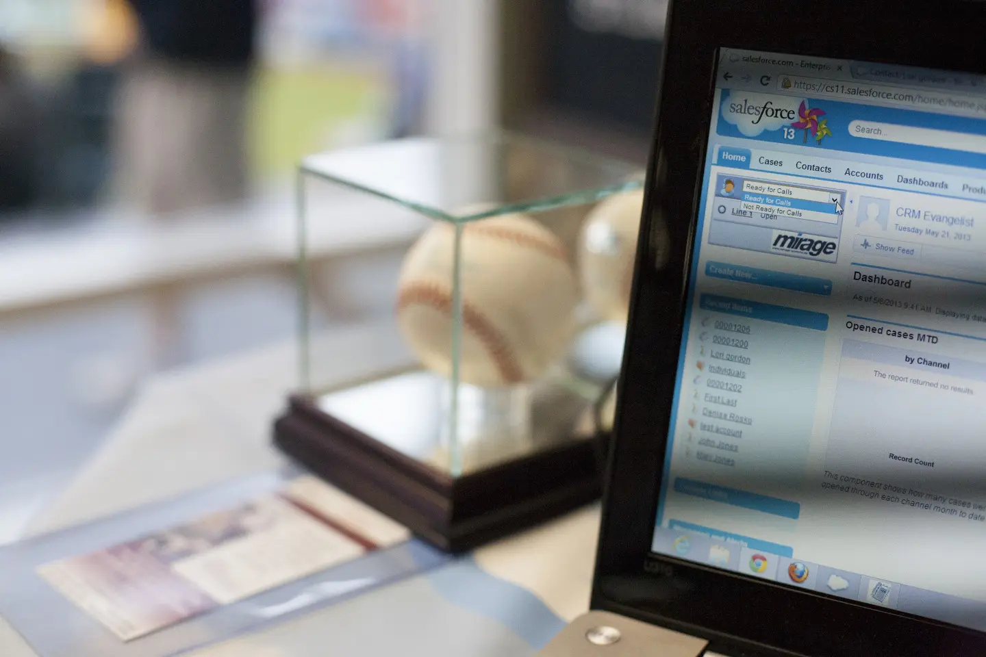 A baseball is displayed in front of the computer.